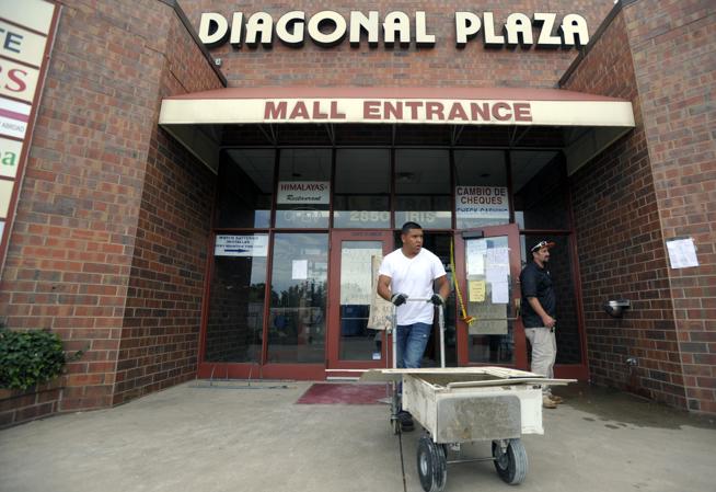 Workers remove damaged items Sept. 8 at the Diagonal Plaza in Boulder after a burst fire line flooded the indoor mall.